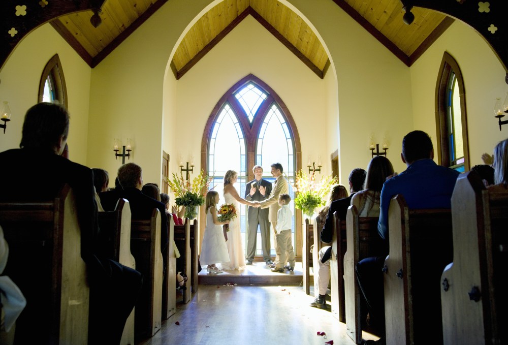 Bride and groom getting married during wedding ceremony in chapel