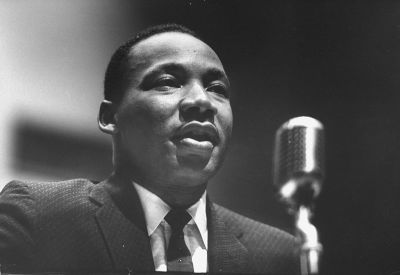 Martin Luther King Jr. speaking into a microphone. (Photo by Donald Uhrbrock/Getty Images)