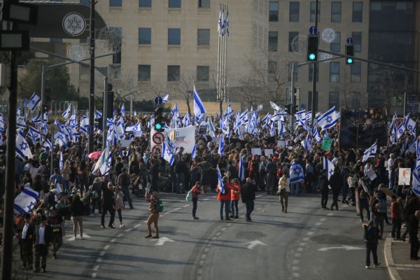 Protesters hold hold Israeli flags infront of the parliament
