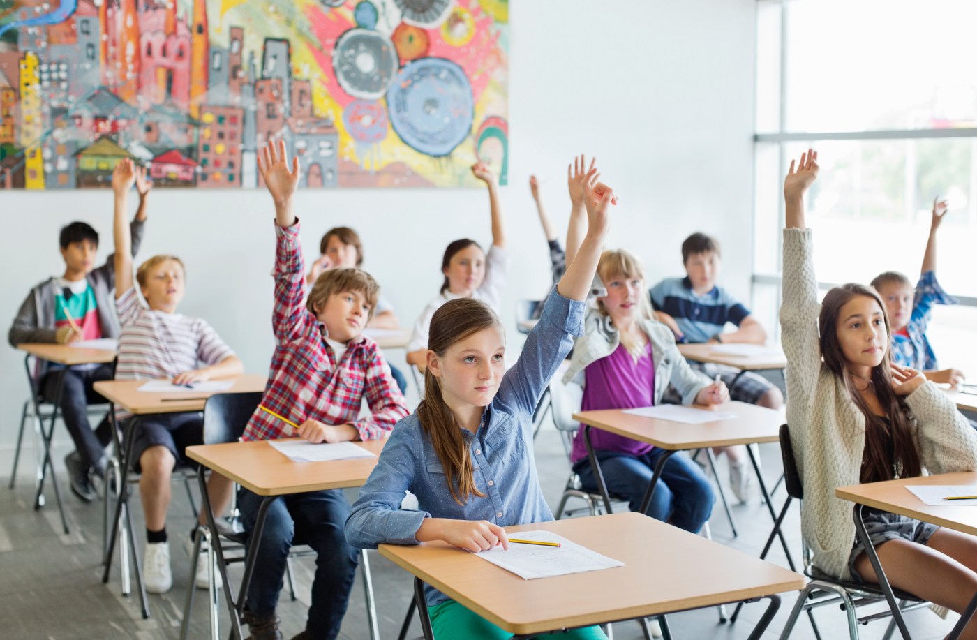 Students with arms raised in classroom