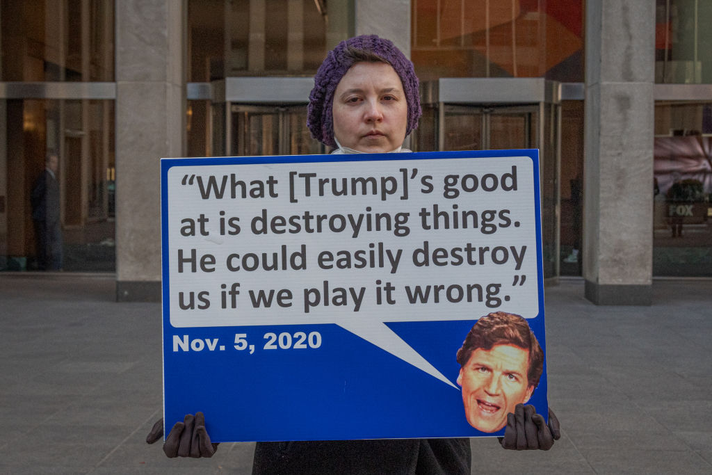 Participant seen holding a sign outside Fox News HQ. Members