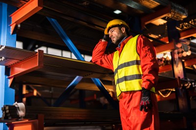 Pensive metal worker standing in aluminum mill.