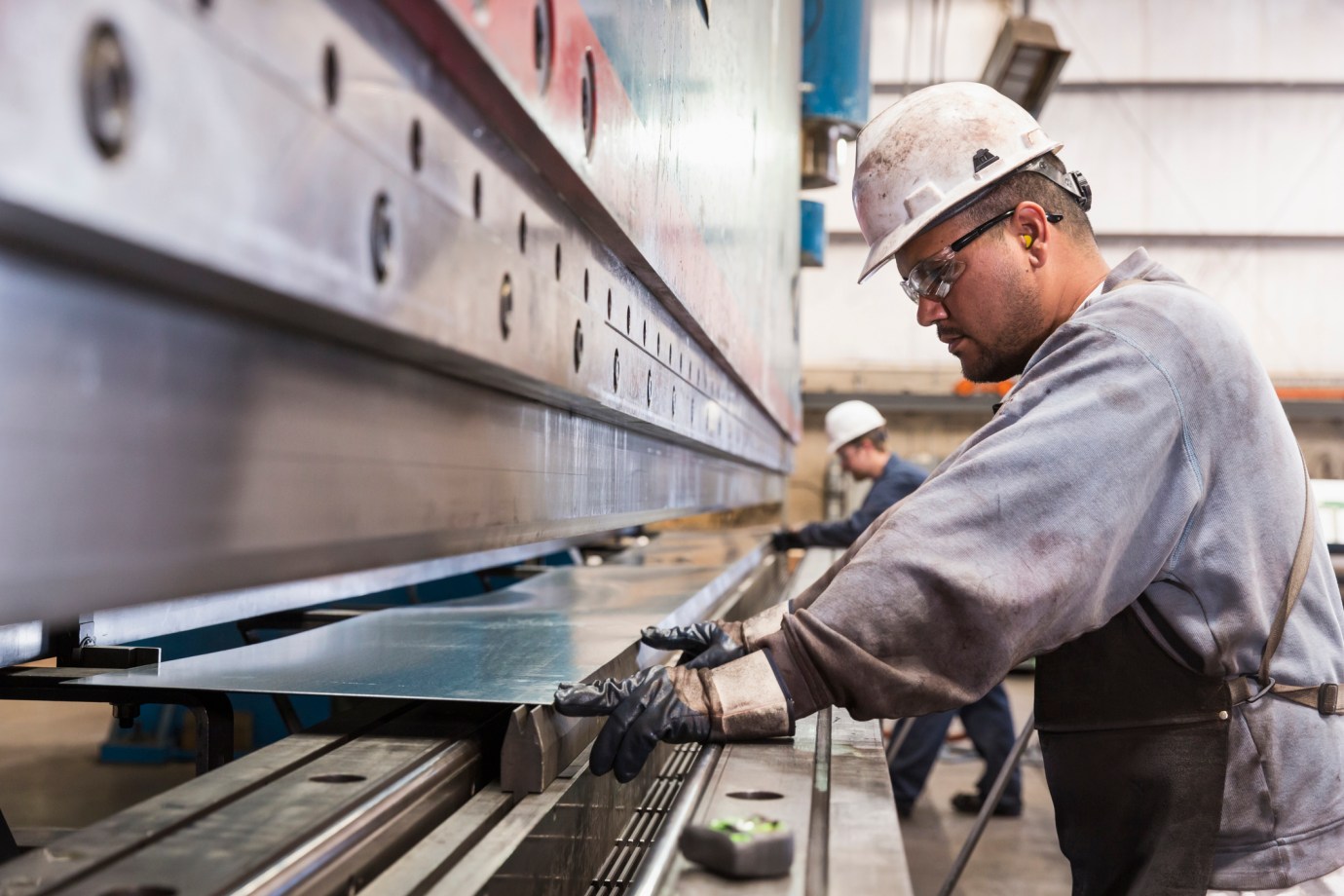 Workers fabricating metal in an American factory (via Getty Images)