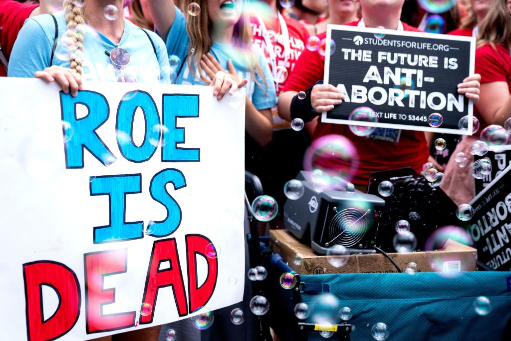 Anit-abortion activists hold signs outside the Supreme Court after the court overturned Roe v. Wade on June 24, 2022. (Photo by Stefani Reynolds / AFP/Getty Images)