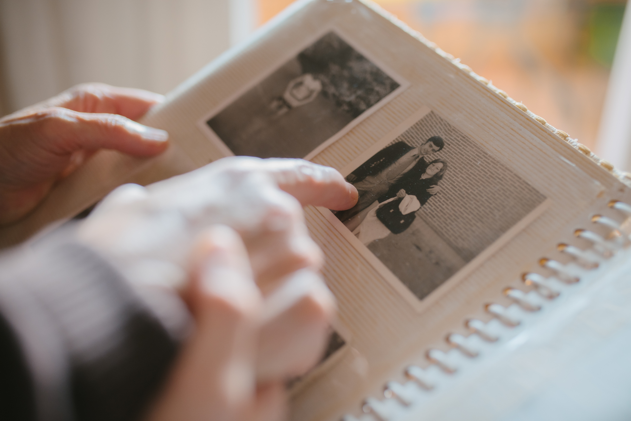 Grandmother sharing memories and stories with her granddaughter while showing her an old family photo album.