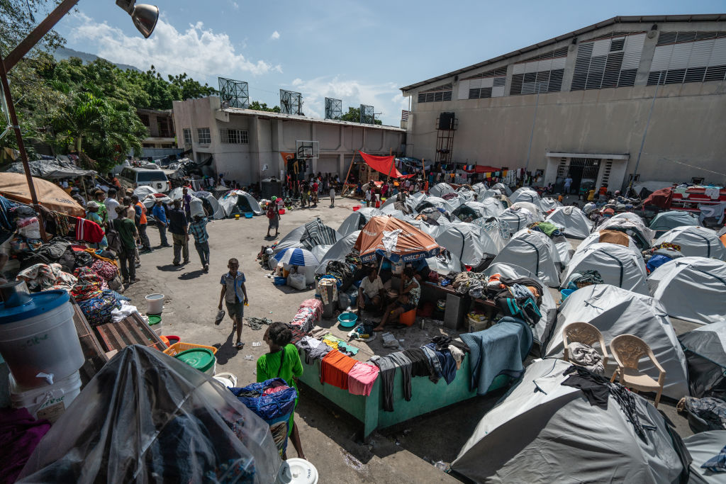 Displaced women and children take shelter at a school gymnasium after fleeing their homes during gang attacks in Port-au-Prince on September 14, 2023. (Photo by Giles Clarke/Getty Images)