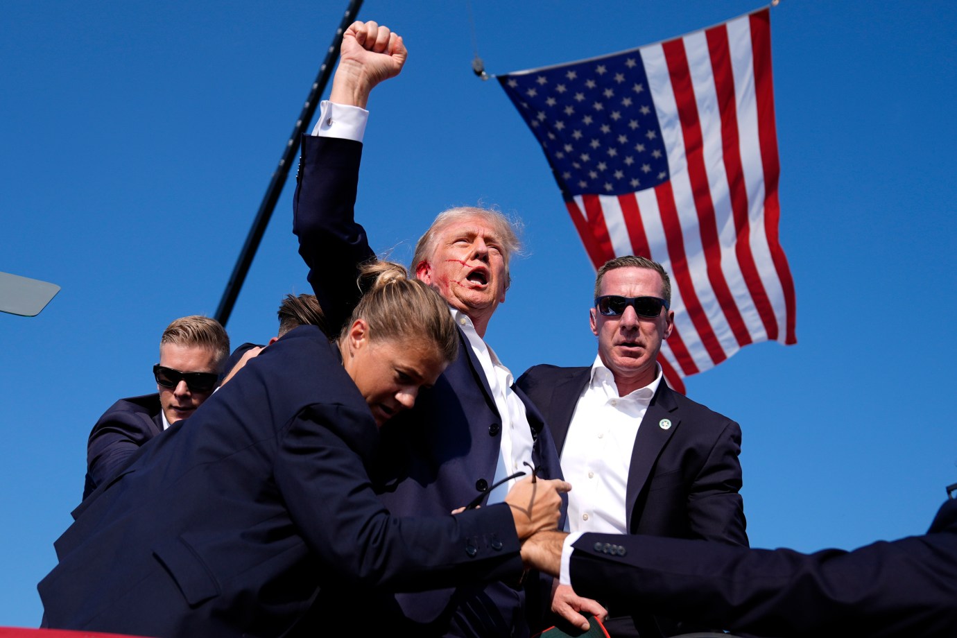 Former President Donald Trump is surrounded by U.S. Secret Service agents at a campaign rally, Saturday, July 13, 2024, in Butler, Pennsylvania. (AP Photo/Evan Vucci)