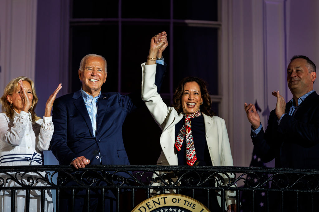 President Joe Biden and Vice President Kamala Harris join hands as they view the fireworks on the National Mall from the White House balcony on July 4, 2024. (Photo by Samuel Corum/Getty Images)