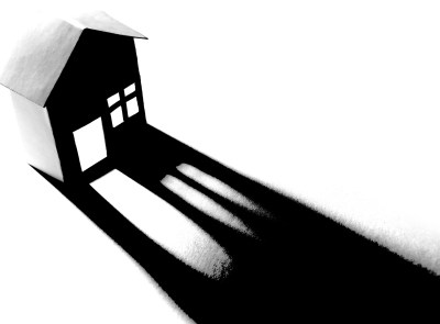 Silhouette of a paper house and long shadow in black and white