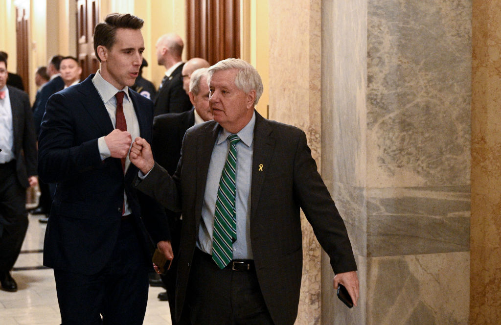 Republican Sens. Josh Hawley (left) and Lindsey Graham fist bump as they depart after President Joe Biden delivered the State of the Union address in Washington, D.C., on March 7, 2024. (Photo by BRENDAN SMIALOWSKI/AFP via Getty Images)