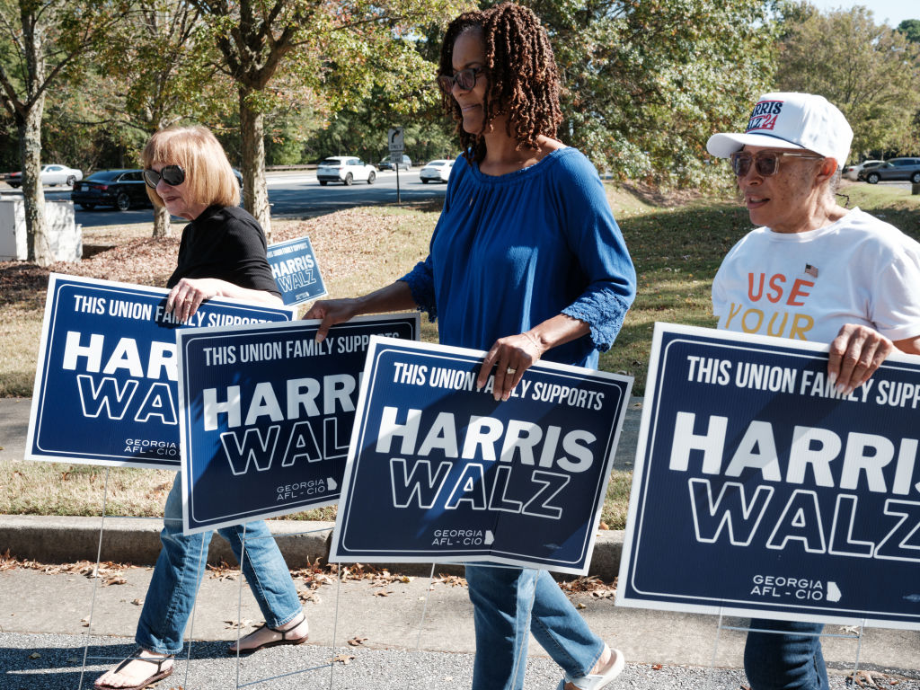 Supporters carry placards supporting Kamala Harris and Tim Walz in Suwanee, Georgia, on October 26, 2024. (Photo by YASUYOSHI CHIBA/AFP via Getty Images)