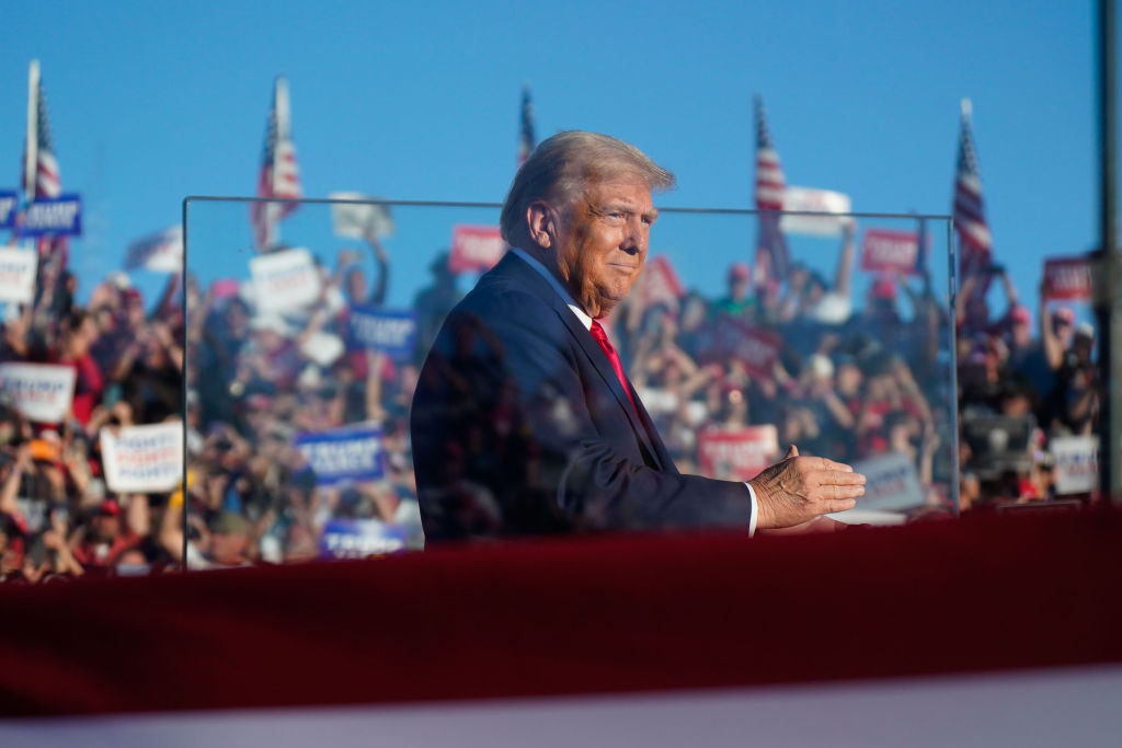 Former President Donald Trump stands behind bullet resistant glass as he arrives to speak at a campaign event at the Butler Farm Show, Saturday, Oct. 5, 2024, in Butler, Pennsylvania. (Photo by Jabin Botsford/The Washington Post via Getty Images)