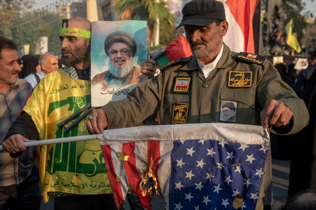 An Iranian demonstrator sets fire to an American flag during an anti-Israeli-American demonstration in Palestine Square on October 8, 2024, in Tehran, Iran.  (Photo by Majid Saeedi/Getty Images)