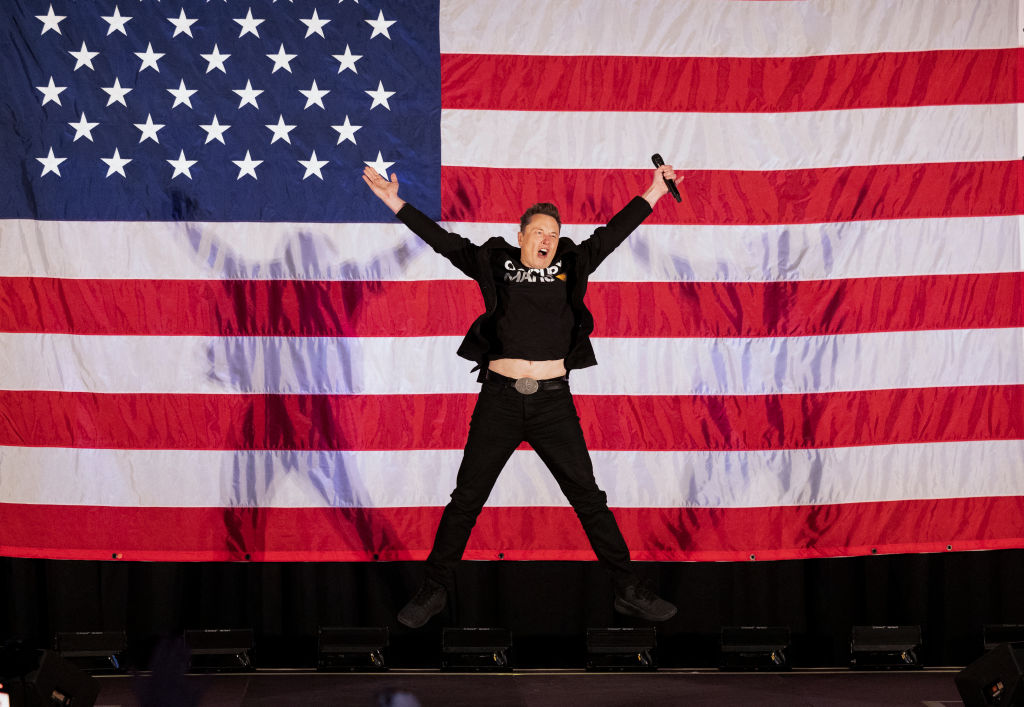 Tesla and SpaceX CEO Elon Musk jumps on stage as he arrives to speak at a town hall event hosted by his America PAC in support of Donald Trump at the Greater Philadelphia Expo Center in Oaks, Pennsylvania, on October 18, 2024. (Photo by RYAN COLLERD/AFP via Getty Images)