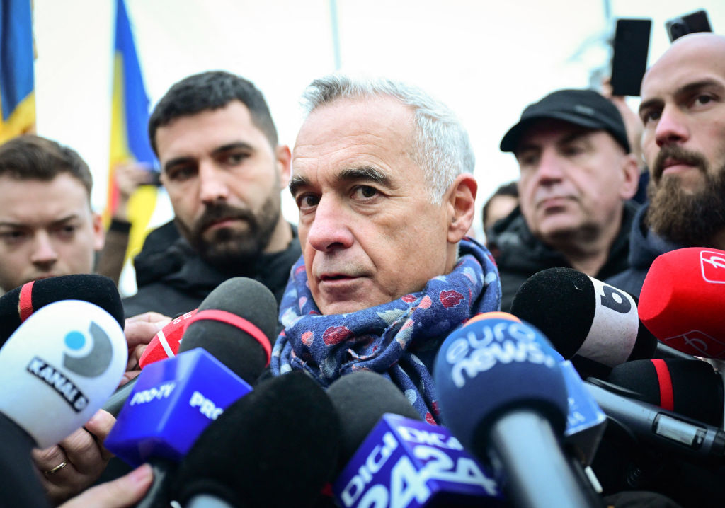 Far-right presidential candidate Catalin Georgescu (center) speaks to the media upon arrival at a protest against the annulment of the presidential elections outside a voting station in Mogosoaia, near Bucharest on December 8, 2024. (Photo by Daniel MIHAILESCU/AFP/Getty Images)