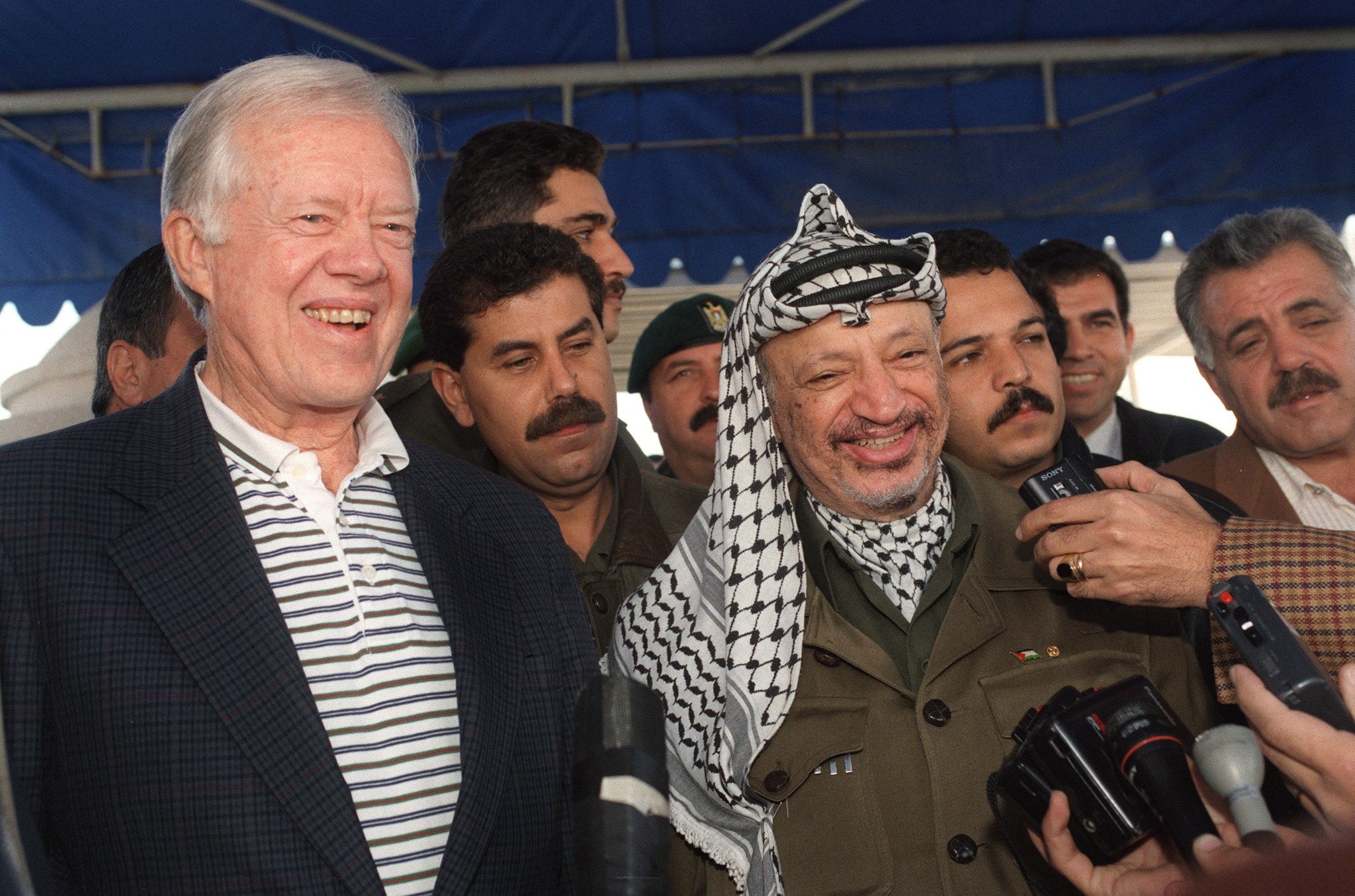 Former Palestinian leader Yasser Arafat and former U.S. President Jimmy Carter give a press conference in Gaza City on January 21, 1996. (Photo by RABIH MOGHRABI/AFP via Getty Images)