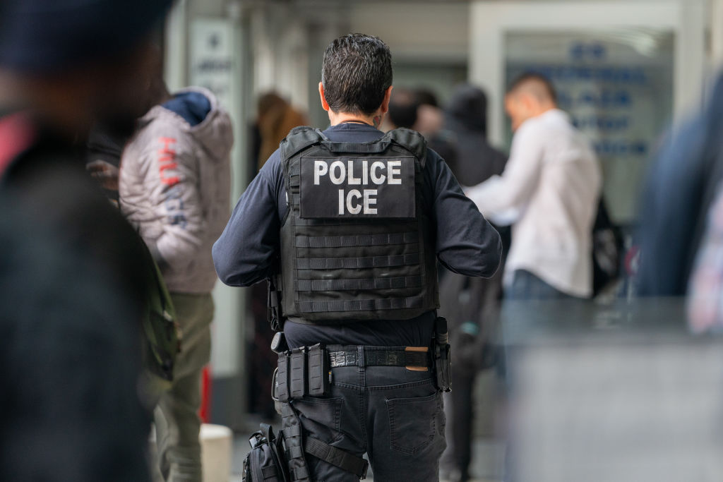 An ICE agent monitors hundreds of asylum seekers being processed in New York City.(Photo by David Dee Delgado/Getty Images)