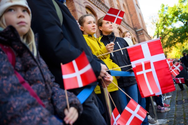 People holding Danish flags wait to welcome King Frederik of Denmark and Queen Mary of Denmark in front of the Schleswig-Holstein state government building on October 22, 2024 in Kiel, Germany. (Photo by Gregor Fischer/Getty Images)