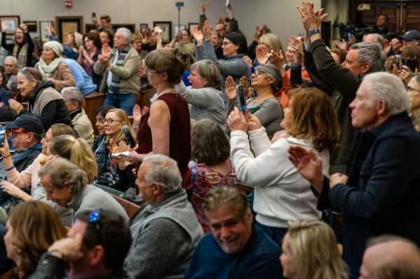 Attendees stand and cheer following a question during a town hall meeting hosted by Republican Rep. Rich McCormick on February 20, 2025, in Roswell, Georgia. (Photo by Elijah Nouvelage for The Washington Post via Getty Images)