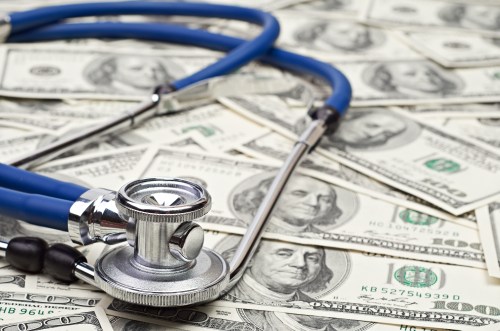 Stethoscope on pile of hundred dollar bills