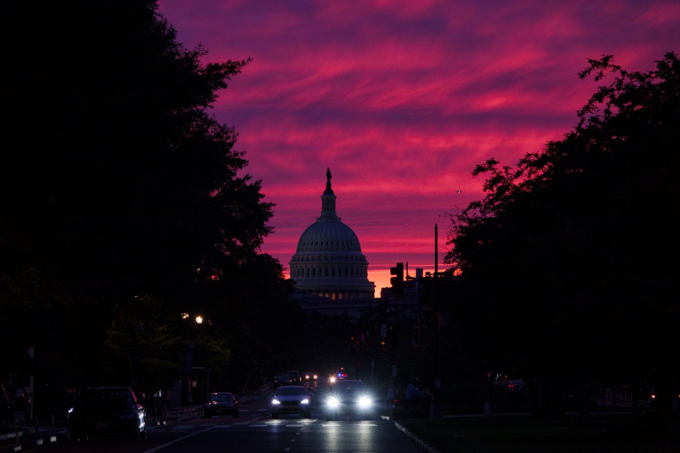 The sun sets behind the U.S. Capitol Building as vehicles drive down Pennsylvania Avenue on June 1, 2025, in Washington, D.C. (Photo by Kevin Carter/Getty Images)