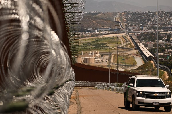 A Customs and Border Protection (CBP) Border Patrol vehicle drives past recently installed concertina wire on a section of border wall fencing along the U.S.-Mexico border between San Diego and Tijuana in California on April 24, 2025. (Photo by Patrick T. Fallon/AFP via Getty Images)