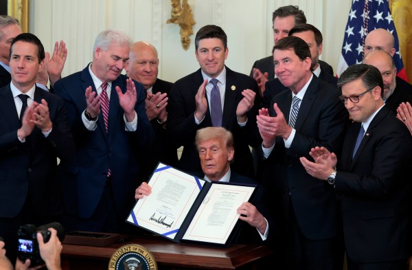 President Donald Trump, surrounded by lawmakers, signs the GENIUS Act into law during a ceremony in the East Room of the White House July 18, 2025, in Washington, D.C. (Photo by Anna Moneymaker/Getty Images)