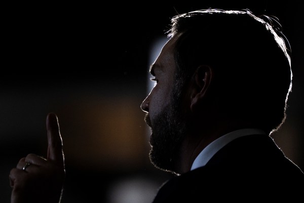 A man in a suit holding up his hand