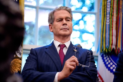 A man in a suit holding glasses