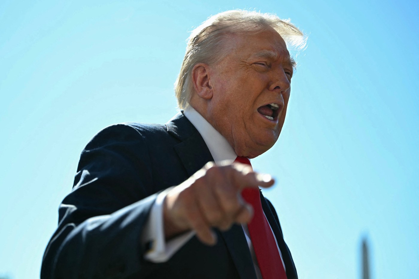 A man in a suit pointing at something