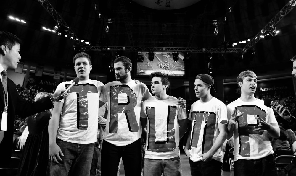 A group of men wearing matching shirts with letters on them