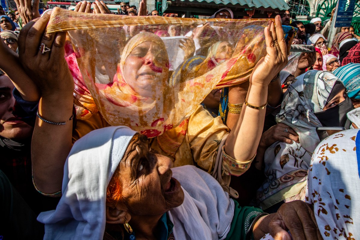 A group of women holding a scarf
