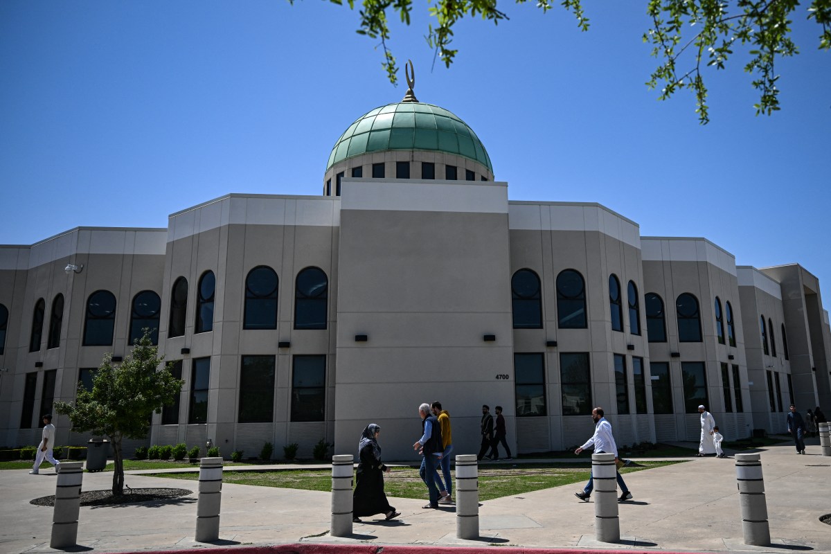A group of people walking in front of a building