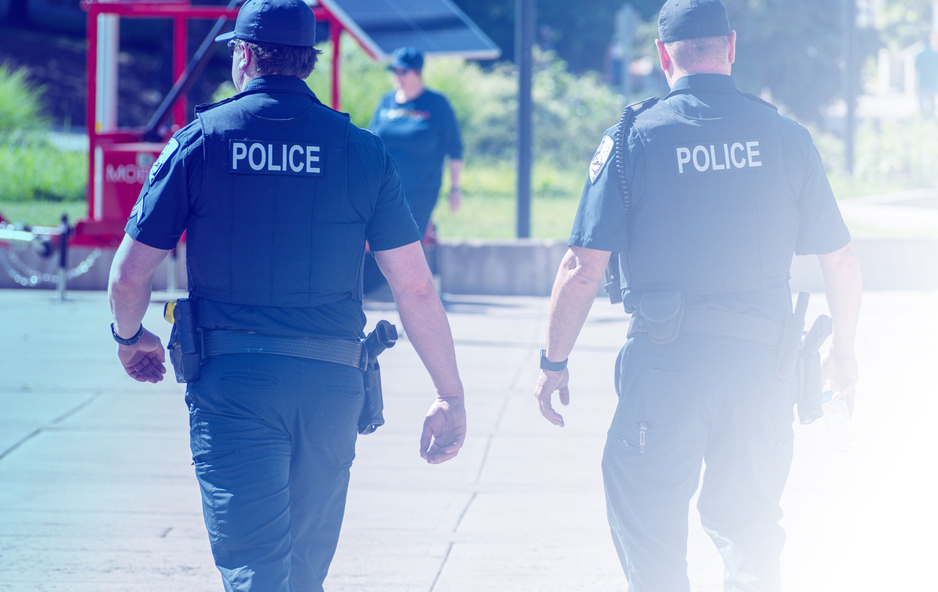 Two police officers walking on a sidewalk