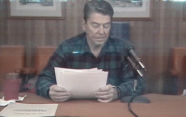 A man sitting at a desk reading papers