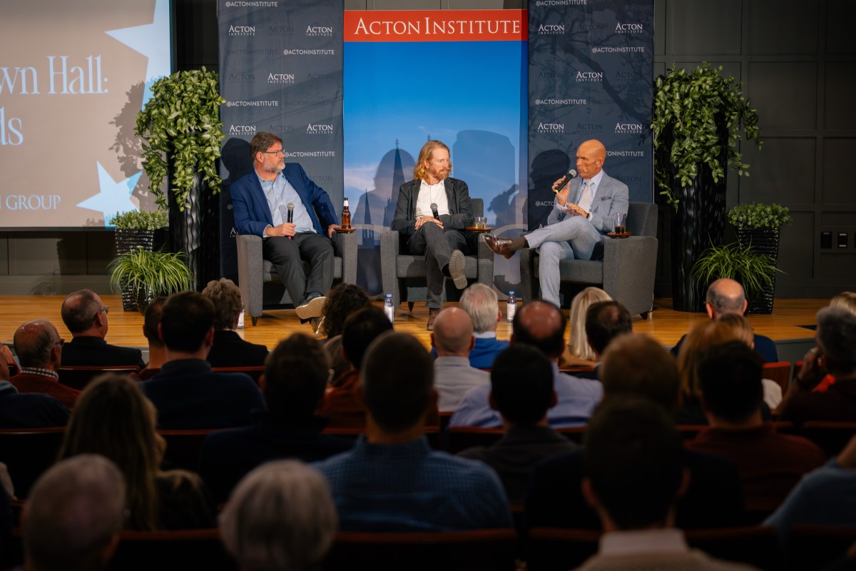 Jonah Goldberg, Peter Meijer, and Kevin Williamson on stage in front of a crowd of people
