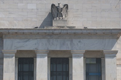A stone building with a statue on the top