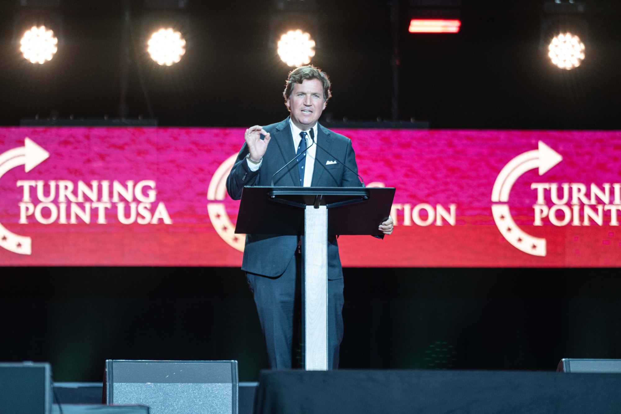 A man standing at a podium giving a thumbs up