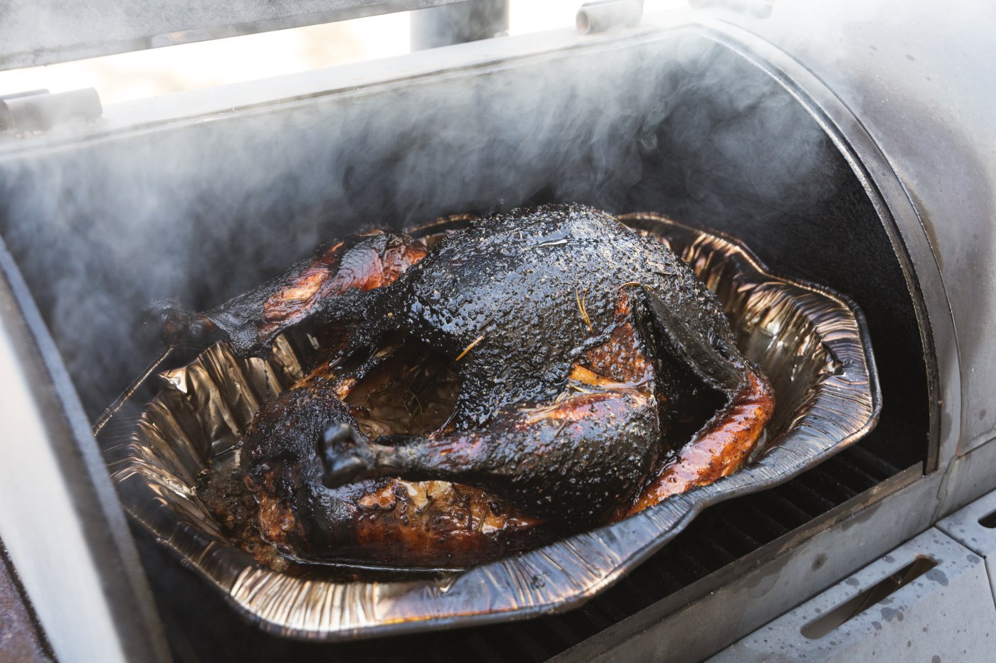 Smoked turkey cooking outdoor on a grill and smoker combination