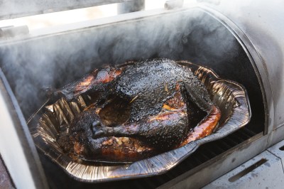 Smoked turkey cooking outdoor on a grill and smoker combination