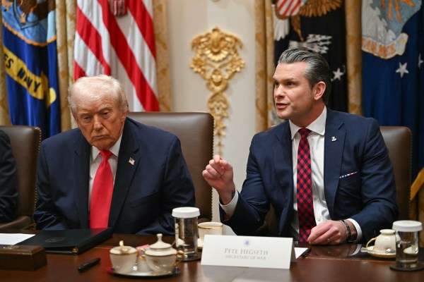 Defense Secretary Pete Hegseth and President Donald Trump during a Cabinet meeting in Washington, D.C., on December 2, 2025. (Photo by Andrew Caballero-Reynolds/AFP/Getty Images)